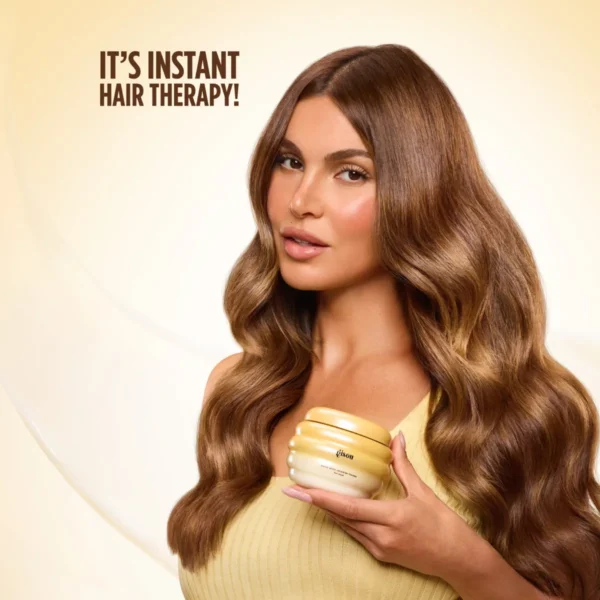 Model with long, glossy waves holding a jar of Honey Gloss Ceramide Therapy Hair Mask