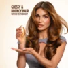 Gisou Honey Gloss Collagen Drops Hair Oil 20ml – view 2 Model with glossy, bouncy brunette waves holding Honey Gloss Collagen Drops Hair Oil