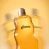 Close-up of the curved Honey Infused Body Oil bottle in warm golden light